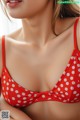 A woman wearing a red and white polka dot bikini top.