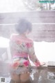 A woman in a kimono sitting in a hot spring.