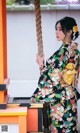 A woman in a kimono standing on a swing.