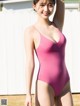 A woman in a pink swimsuit posing for a picture.